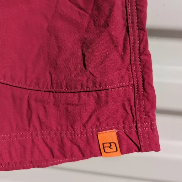 Ortovox fuscia hiking shorts with yellow and orange accents