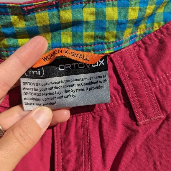 Ortovox fuscia hiking shorts with yellow and orange accents