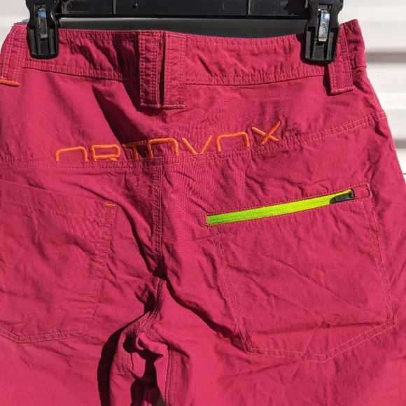 Ortovox fuscia hiking shorts with yellow and orange accents