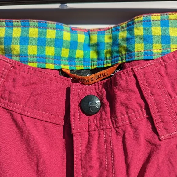 Ortovox fuscia hiking shorts with yellow and orange accents