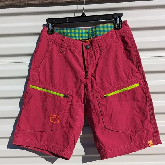 Ortovox fuscia hiking shorts with yellow and orange accents