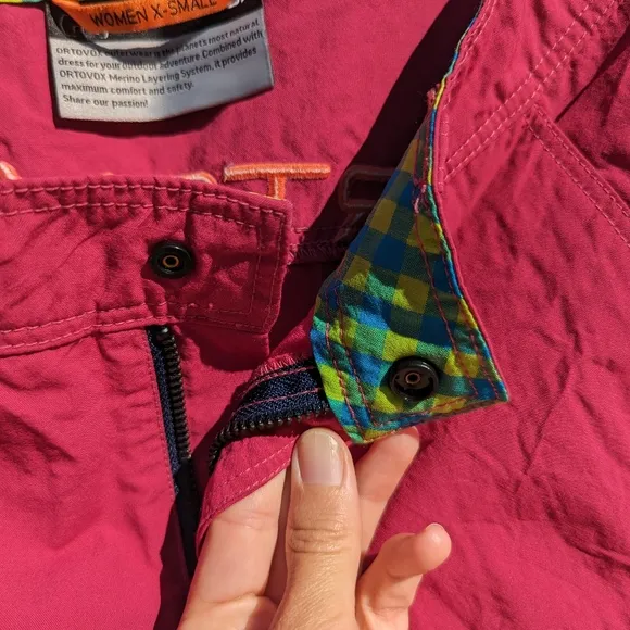 Ortovox fuscia hiking shorts with yellow and orange accents